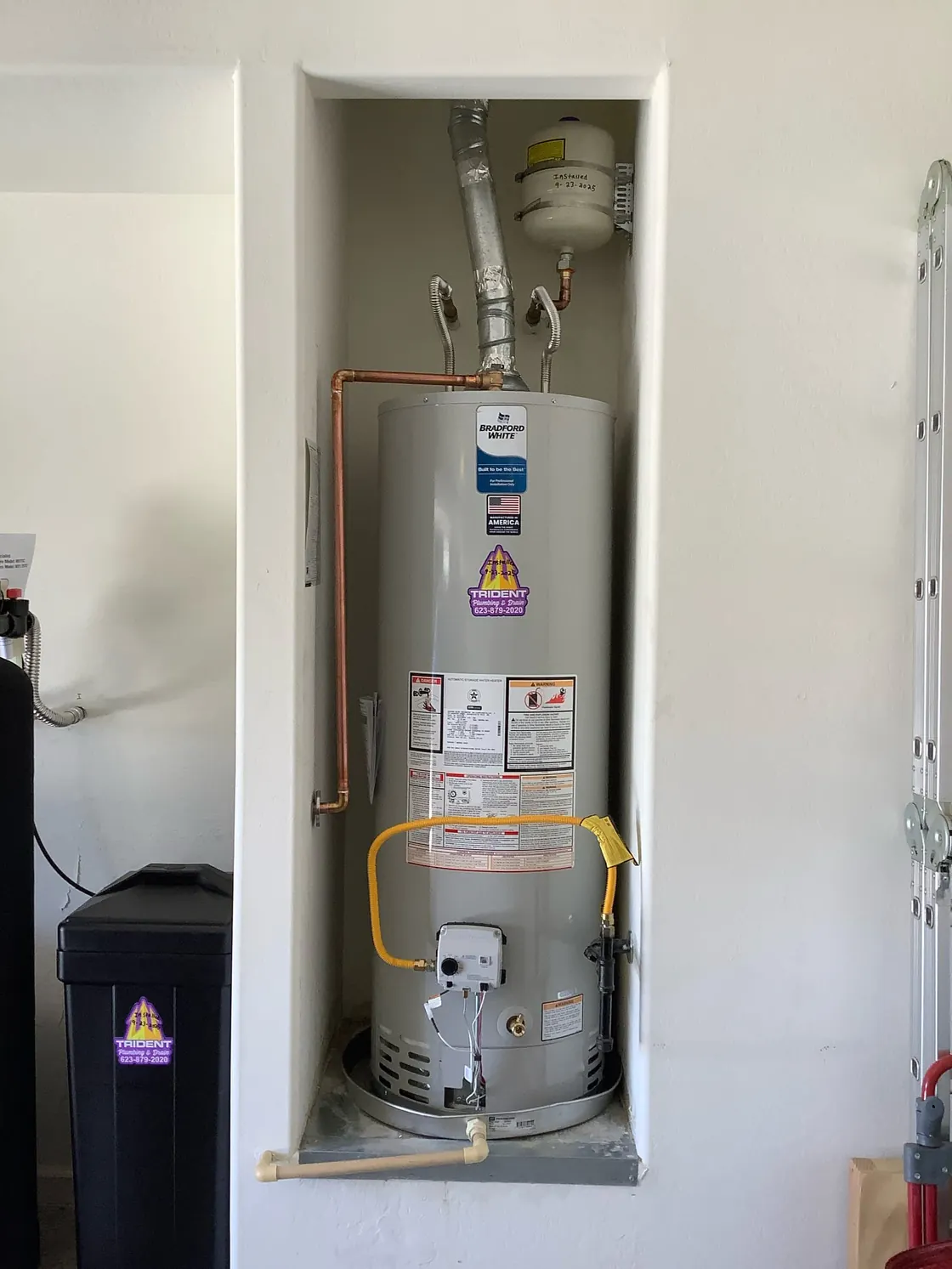 A tank water heater installed in a utility closet