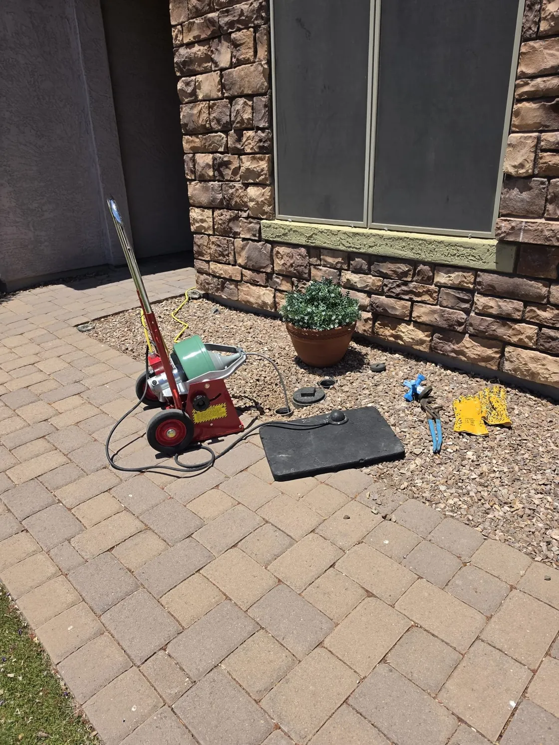 Red drain cable equipment set up beside a patio