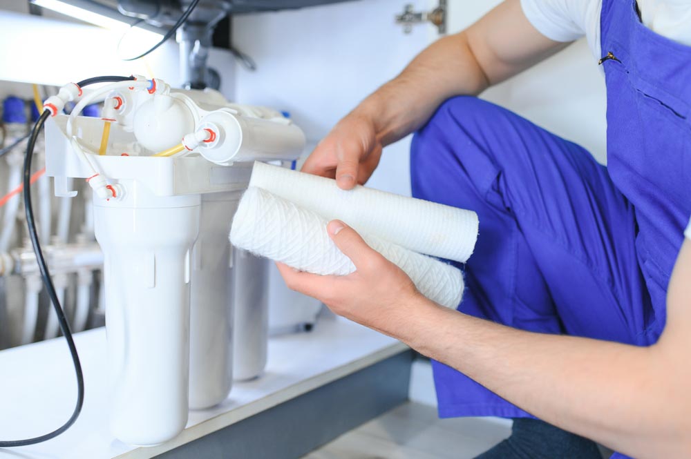 a person replacing an old water filter