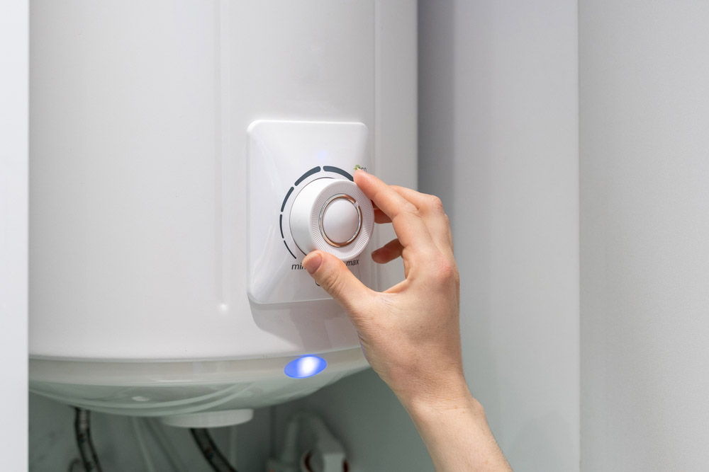 a person turning off their water heater power supply