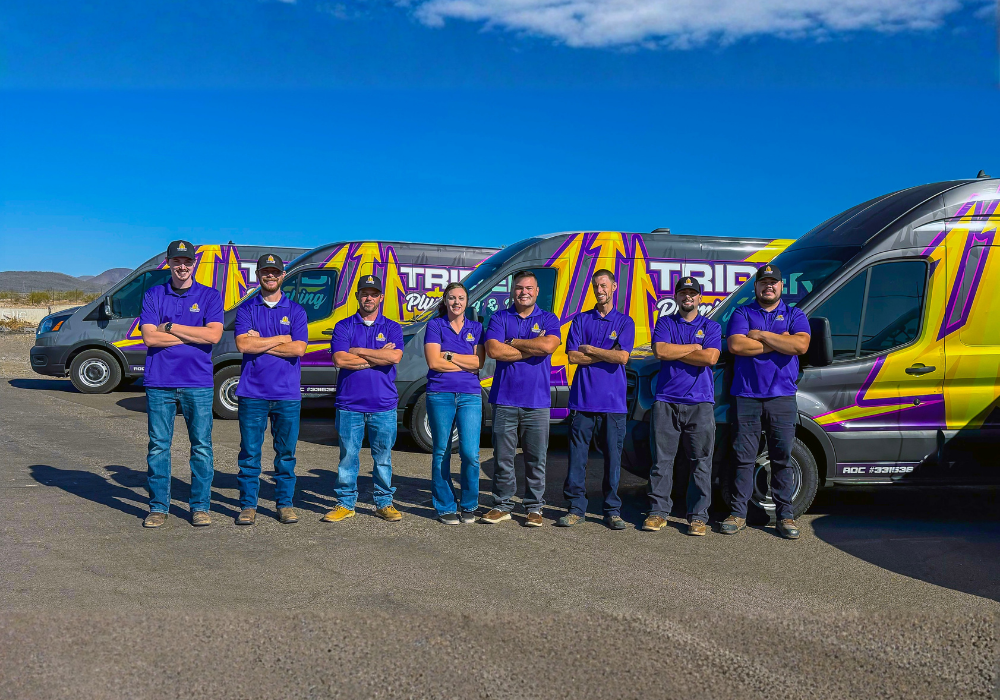 Trident Plumbing Team standing in front of service vehicle fleet
